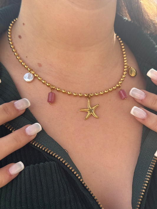 Collier à charms en acier inoxydable Or avec une chaîne et 5 bijoux charms (etoile de mer, coquillage, perle rose, perle nacrée).